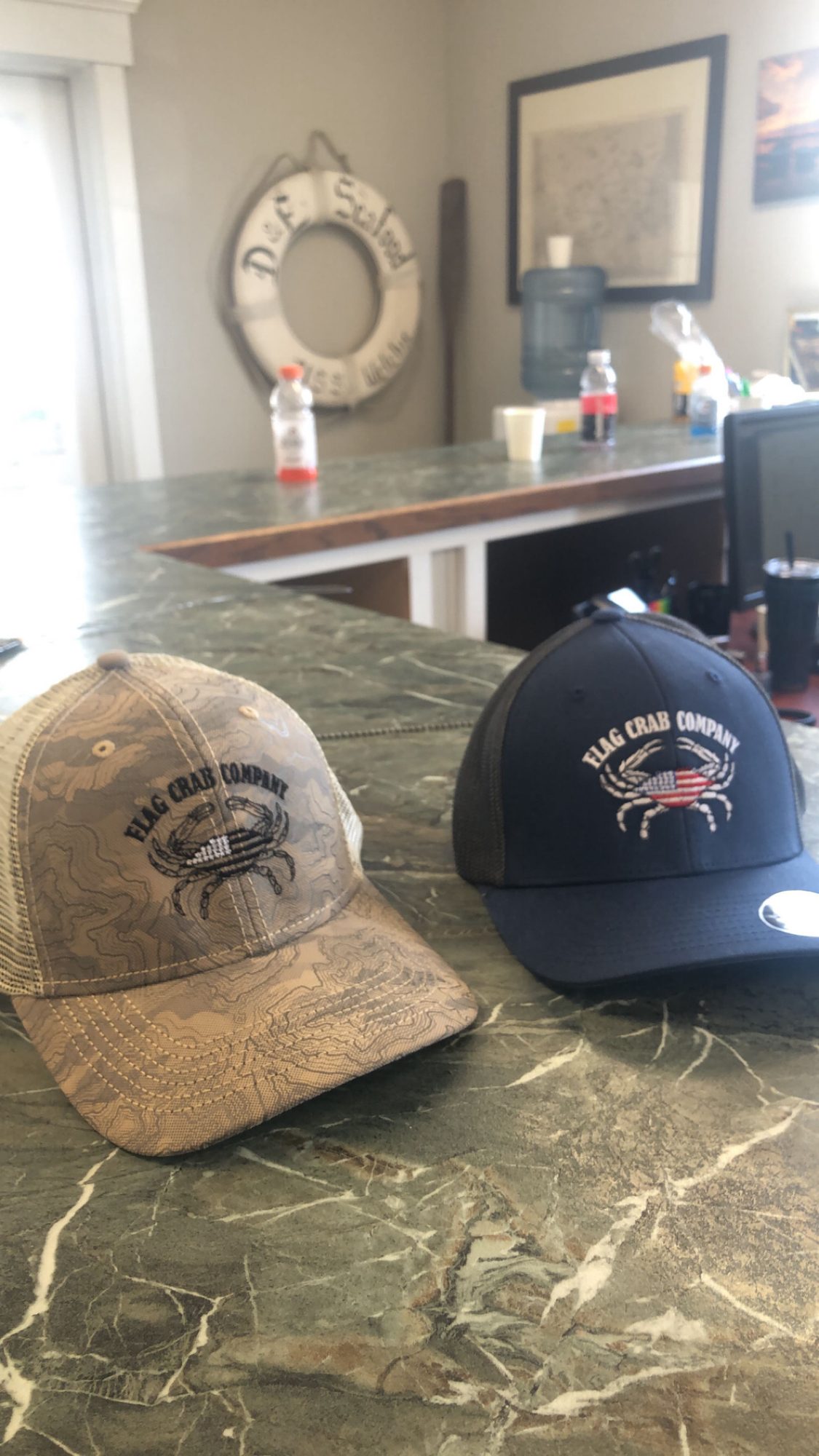Flag Crab Company hats on the office counter
